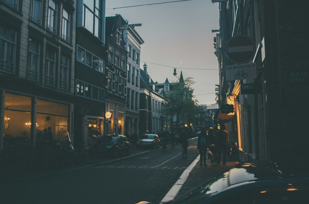 Street in a European city at dusk with warm window lights
